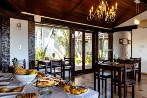 a dining room with a table with food on it at Arambare Buzios Hotel in Búzios