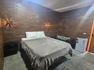a bedroom with a bed and a brick wall at Hotéis Online in Boa Vista