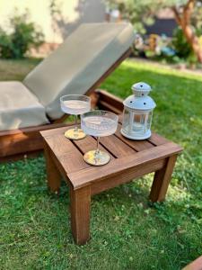 a wooden table with two glasses and a lantern on it at Apartment Kala in Varaždin
