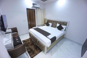 a bedroom with a bed with white sheets and pillows at Hotel Prabhawati Palace Near Railway Station and Sri Vishwanath Temple Varanasi in Varanasi