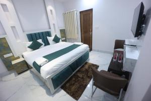 a bedroom with a bed and a television in it at Hotel Prabhawati Palace Near Railway Station and Sri Vishwanath Temple Varanasi in Varanasi