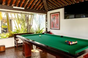 a pool table in a living room with at Arambare Buzios Hotel in Búzios