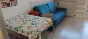 a table and a blue couch in a room at les Lauzes in Les Menuires