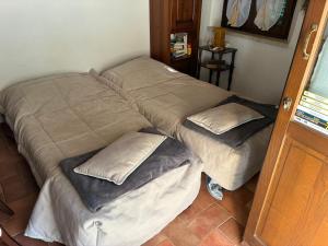 two beds with pillows in a corner of a room at La Tua Casina in Torrenieri