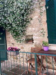 a table and chairs in front of a wall with flowers at La Tua Casina in Torrenieri +2 photos