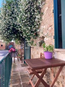 a wooden picnic table on a balcony with flowers at La Tua Casina in Torrenieri
