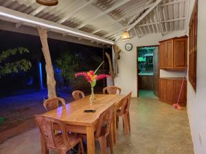 a wooden table with chairs and a vase of flowers on it at Nature Kingdom Sri Lanka in Hambegamuwa