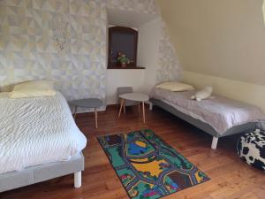 a bedroom with two beds and a rug at Gite des écureuils in Obernai