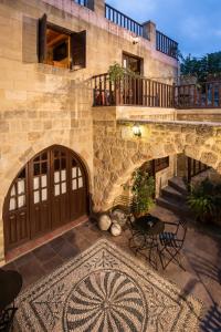 a stone building with a wooden door and a rug at Camelot Traditional & Classic Hotel in Rhodes Town