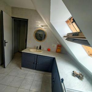 a bathroom with a sink and a mirror on the wall at Le petit cocon in Linas