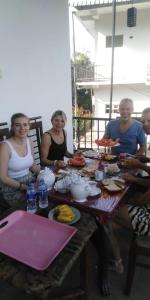 a group of people sitting around a table with food at Dilshan Cottage in Ella +32 photos