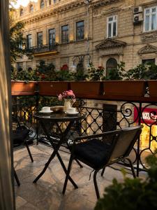 a table and chairs on a balcony in front of a building at BS Studios in Baku