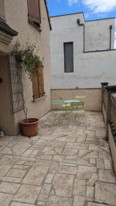 a patio with a table and chairs and a building at Le petit cocon in Linas