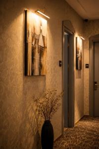 a hallway with a vase on a wall with a painting at BS Studios in Baku