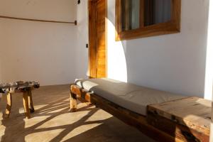 a bed sitting in a room with a table at Faro Resort in Nungwi
