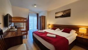 a bedroom with a large bed with a red blanket at Villa Maritima in Grzybowo
