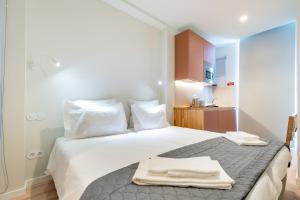 a bedroom with a bed with two towels on it at Studio FAMEUSE in Matosinhos +8 photos