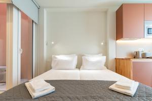 a bedroom with a bed with two towels on it at Studio FAMEUSE in Matosinhos