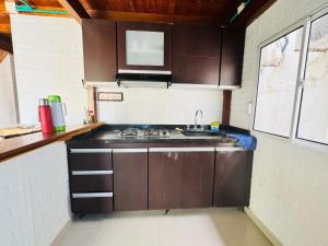a kitchen with a stove and a sink in it at Cabaña Niva in Coveñas