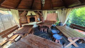 an outdoor dining area with wooden tables and a fireplace at Villa Maritima in Grzybowo