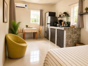 a room with a bed and a table and a kitchen at Bon Bini Kokolishi in Willemstad