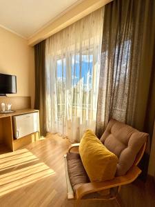 a living room with a couch and a large window at Hotel Perla in Satu Mare