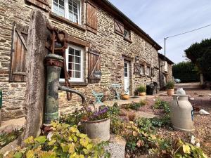an old water fountain in front of a brick building at Le Gîte des Violettes in Ger
