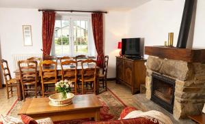a living room with a table and a fireplace at Le Gîte des Violettes in Ger