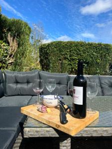 a bottle of wine sitting on a table with wine glasses at Le Gîte des Violettes in Ger