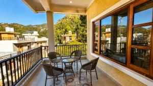 a balcony with a table and chairs and a view at Summer Stays Boho in Bhīm Tāl