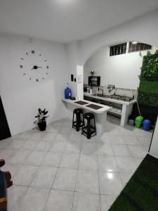 a white room with a table and a clock on the wall at Galápagos Islands-Apartment in Santa Cruz in Puerto Ayora