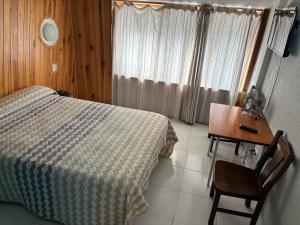 Un dormitorio con una cama y un escritorio y una mesa y una silla. en Hotel Viar, en Cabezón de la Sal