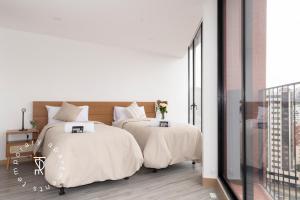 a bedroom with two beds with white sheets at Top Rentals EpiQ in Quito