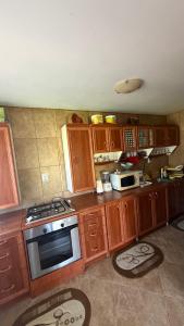 a kitchen with wooden cabinets and a stove top oven at Vacation home E in Borsec +3 photos