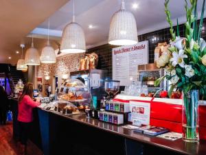 a woman standing at the counter of a restaurant at Mercure Melbourne City Centre in Melbourne