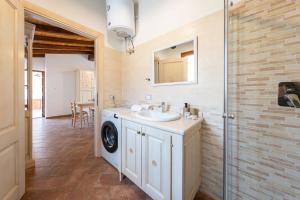 a bathroom with a sink and a washing machine at Agriturismo Cirra in Tertenìa +75 photos