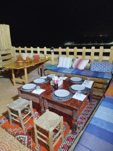 a table and chairs and a couch on a patio at Ifni Flow Seafront surfhouse in Sidi Ifni