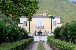 an old house with a garden in front of it at Tenuta Torellone in San Potito Sannitico