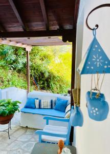 a patio with a couch and a blue umbrella at Villa Panorama Garden Chorto in Chorto