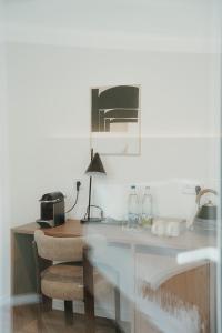 a desk with a chair and a table with a lamp at The Haus KAI Nuremberg in Nuremberg