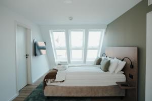 a bedroom with a large bed with a large window at The Haus KAI Nuremberg in Nuremberg