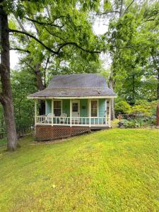 a small green house in a field with trees at Blue Crystal Hideaway BnB in Eureka Springs