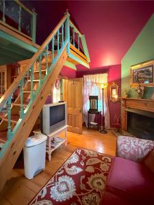 a living room with a staircase and a tv at Blue Crystal Hideaway BnB in Eureka Springs