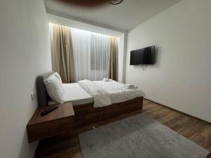 a bedroom with a bed and a tv on the wall at Apartmani Pužić in Kopaonik