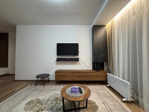 a living room with a tv and a table at Apartmani Pužić in Kopaonik