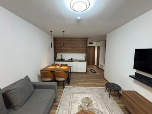 a living room with a couch and a table at Apartmani Pužić in Kopaonik +7 photos