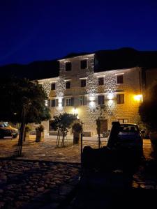 a building with a car parked in front of it at night at Villa Old Mariner in Kotor