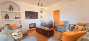 a living room with two couches and a tv at Casas do Monte I - T3  +7 photos