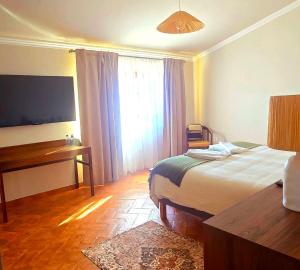 a bedroom with a bed and a desk and a window at Casas do Monte I - T3 