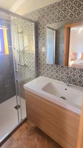 a bathroom with a tub and a shower and a sink at Casas do Monte I - T3 